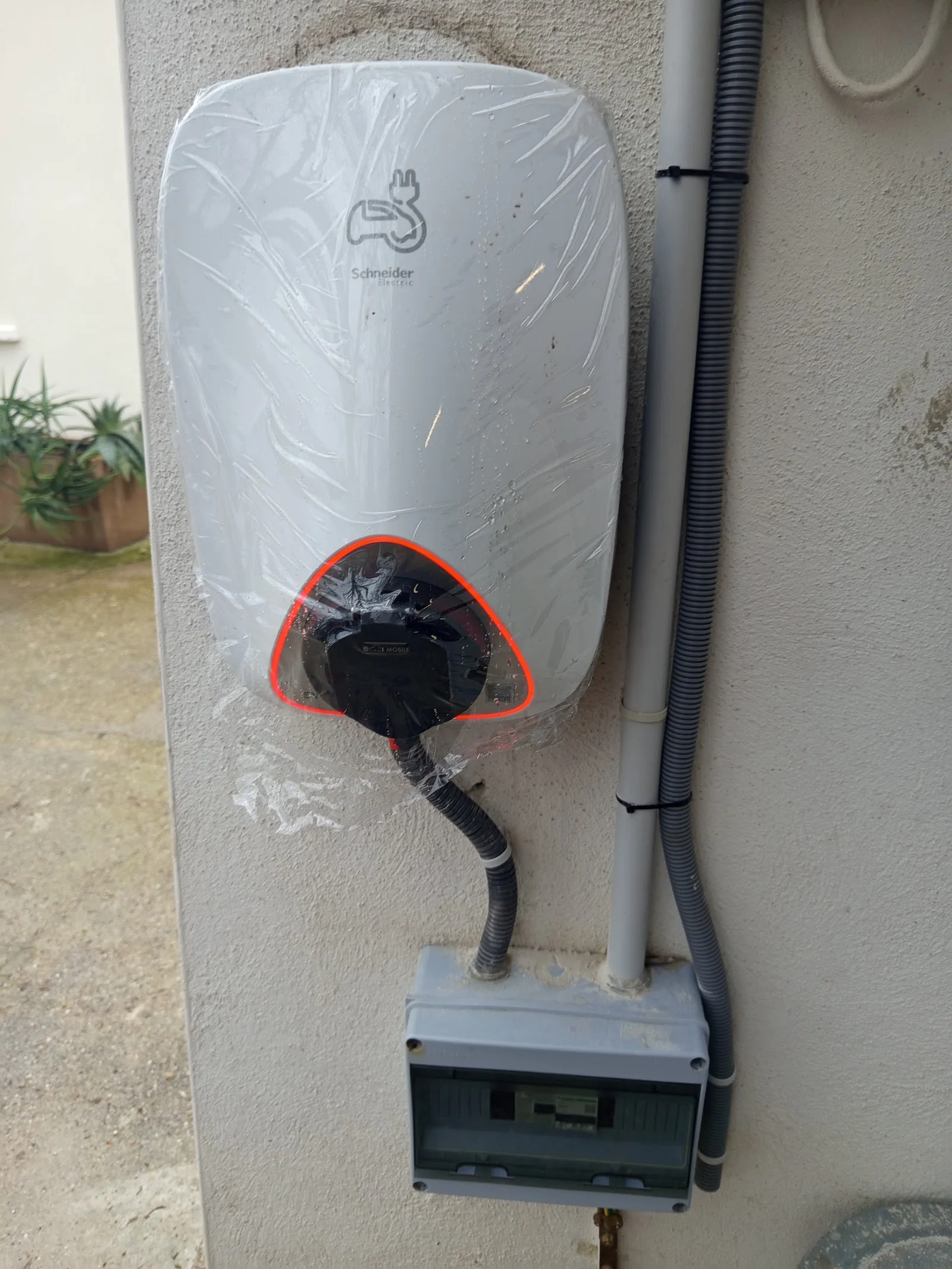 Borne de recharge pour véhicule électrique posée en façade par M.A.S ELEC 30, encore sous film de protection
